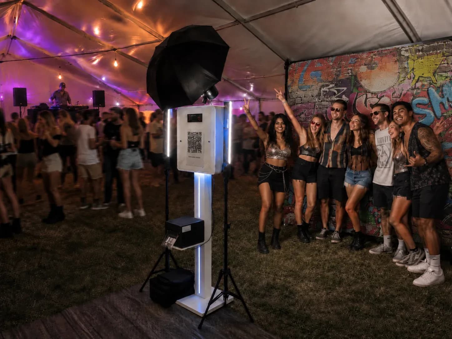 Festival guests posing beside the PhotoBoothPro booth at an outdoor party
